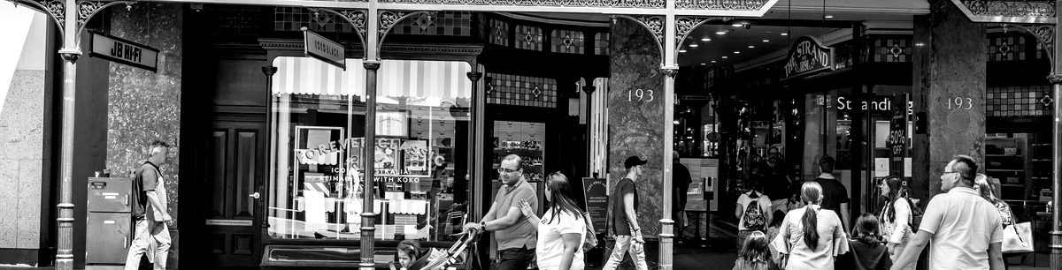 Pedestrians outside shopfronts on a retail strip